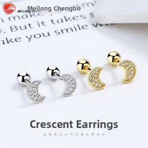 Detail of silver and gold crescent moon earrings with cubic zirconia and screw ball backs