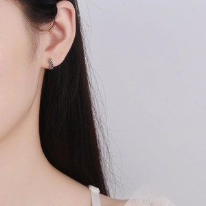 Orecchini a cerchio a C in argento Thai su modella con texture vintage raffinata
