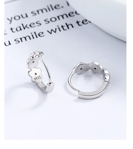 Close-up of S925 sterling silver hoop earrings featuring floral relief and hallmark