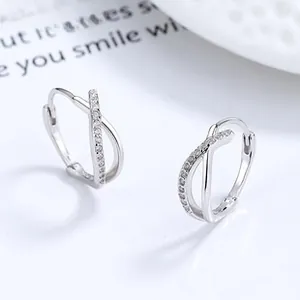 Detail of silver 925 Mobius earrings with white zircon pavé setting on white background