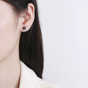 Clou d'oreille noir en forme de puzzle avec micro-pavage de pierres sur le lobe