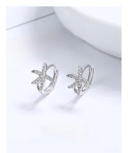 Macro view of sterling silver starfish hoop earrings with sparkling paved zircons