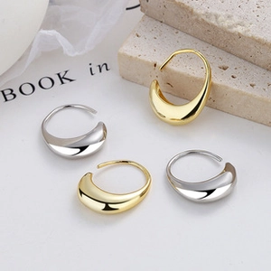 Close-up of sleek liquid metal teardrop earrings in polished gold and silver finishes