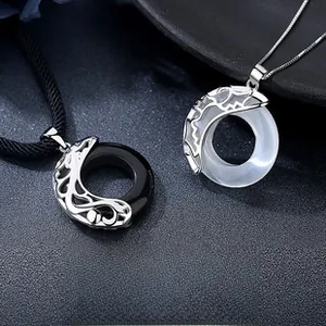 Detail of couple necklace pendants with sun moon silver motifs and stones