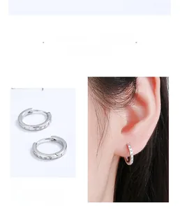 Détail de créoles en argent sterling S925 avec zircons portées par un mannequin