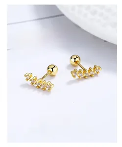 Macro view of gold crescent earrings with five round zircons and screw ball back