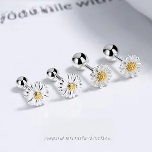 Macro shot of 925 silver daisy stud earrings with white petals and yellow centers