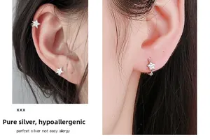 Détail de boucles d'oreilles étoile en argent portées en puce et bague d'oreille