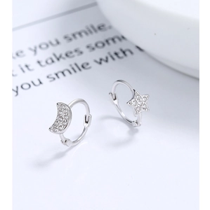 Gros plan de boucles d'oreilles lune et étoile en argent serties de zircons blancs