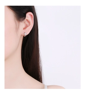 Close-up of 925 sterling silver starfish earrings with cubic zirconia on female model