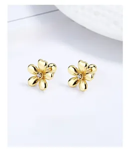 Detailed macro of gold flower studs with zircon center and secure screw back closure