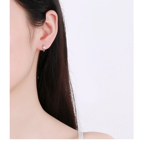 Gros plan d'une boucle d'oreille étoile en argent 925 avec zircon brillant sur l'oreille
