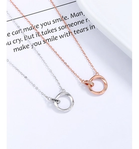 Close-up of Mobius couple necklaces with interlocking rose gold and silver rings