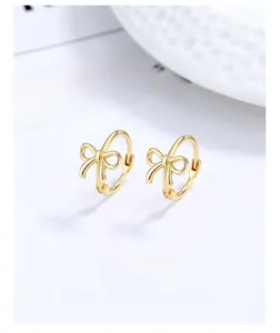 Nahaufnahme eleganter goldener Schleifen-Ohrringe mit polierter Oberfläche auf weißem Grund