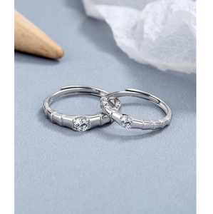 Macro shot of 925 sterling silver couple rings with bamboo texture and sparkling stones
