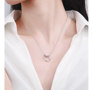 Polished silver Mobius loop pendant necklace worn by model on a white shirt