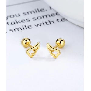 Macro detail of golden angel wing earrings with secure screw-back ball closures on book