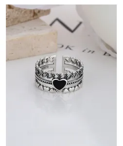 Macro shot of vintage S925 sterling silver triple-layer ring with black enamel heart charm