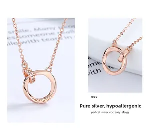 Macro detail of rose gold Mobius pendant with Fall in love engraving and zircon stones