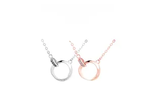 Macro shot of silver and rose gold Mobius necklaces with 'Fall in love' engraving