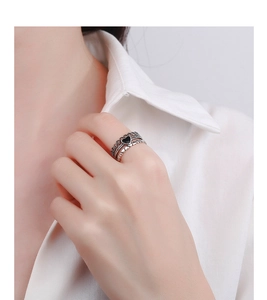 Detail of retro S925 silver triple-layered ring with black heart and crown on model hand