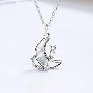 Macro shot of 925 silver necklace with crescent moon pendant and mother of pearl detail