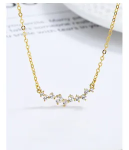 Macro shot of gold smile necklace with glittering zircon stones on clean background