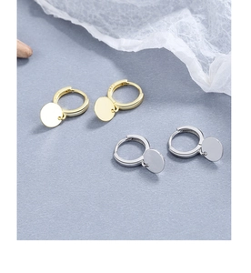 Macro shot of S925 sterling silver stamp on minimalist gold and silver hoop earrings