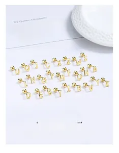 Macro shot of 925 silver 26 letter gold studs with secure screw ball back fasteners