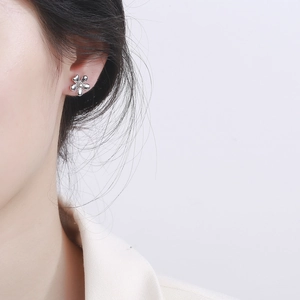 Minimalist 925 sterling silver flower stud earring worn on ear with polished finish