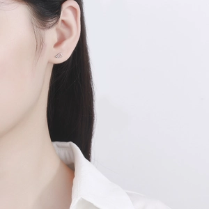 Minimalist 925 sterling silver angel wing screw back earrings on model ear