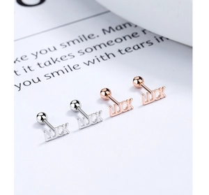 Close-up of LUCK letter earrings with screw back design in silver and rose gold