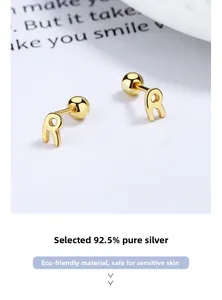 Macro detail of S925 sterling silver golden letter R stud earrings with screw back design