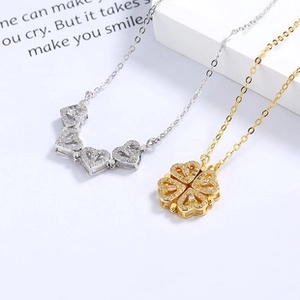 Close-up of magnetic clover necklace in gold and silver showing the foldable heart design
