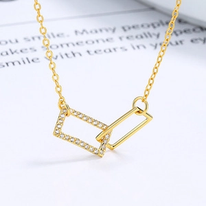 Macro shot of interlocking rectangular pendants with zircons and polished gold finish