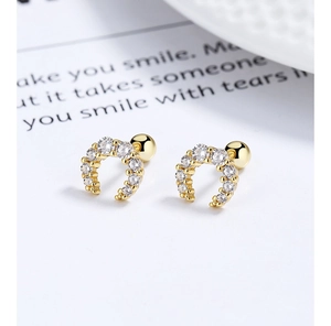 Macro shot of 925 silver gold-plated U-shaped earrings with sparkling cubic zirconia stones