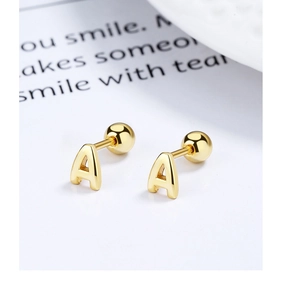 Macro shot of 925 silver letter A screw back stud earring with polished golden finish