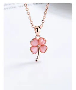 Detail of rose gold clover pendant with pink cat's eye stone and zircon setting