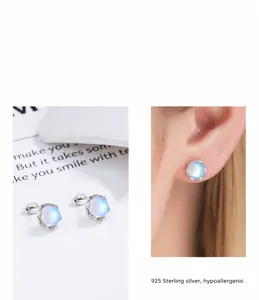 Detailed close-up of S925 sterling silver moonstone stud earrings with blue glow effect