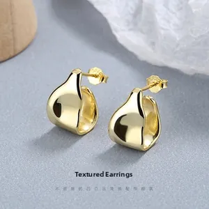 Detailed close-up of golden arched earrings with S925 silver needle and wavy texture