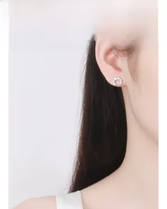 Detailed view of a small 925 sterling silver crescent moon stud earring with zircons
