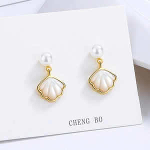Detail of 925 silver clover earrings with white shell inlay and elegant pearl accents
