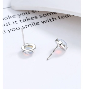 Macro detail of S925 sterling silver earring featuring aurora moonstone in claw setting