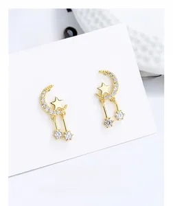 Detail of star and crescent moon earrings with cubic zirconia tassels on white card