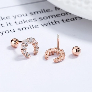 Detailed close-up of rose gold crescent earrings with zircons and screw back closure