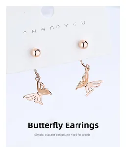 Detail of rose gold butterfly drop earrings with hollow design on white card