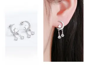 Detailed view of silver star and moon tassel earrings with sparkling cubic zirconia