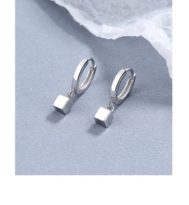 Macro view of geometric silver earrings featuring sleek square charms and leverback hoops