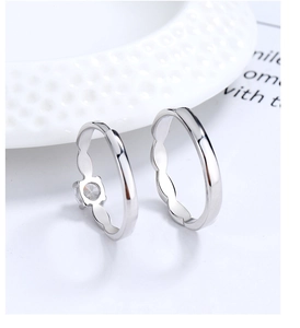 Close-up of Mobius silver rings for couples with wave design and sparkling zircon stone