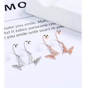 Macro detail of S925 stamped bow-shaped earrings in silver and rose gold finishes